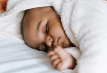 Sleeping black infant baby on bed
