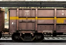 a train car sitting on the tracks under a bridge