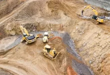 top view photography of four heavy equipment on quarry at daytime