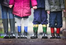 four children standing on dirt during daytime