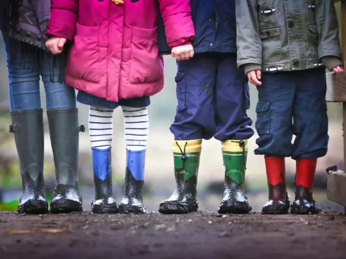 four children standing on dirt during daytime