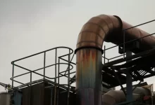 a metal pipe with rust on it near a building