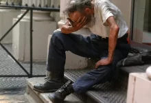a man sitting on a step with his head in his hands