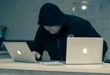 man in black hoodie using macbook