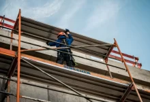 a man on a scaffold working on a building