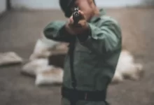 soldier pointing rifle during daytime
