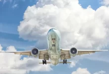 gray and white airplane on flight near clear blue sky