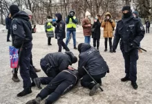 a group of people standing around a man on the ground