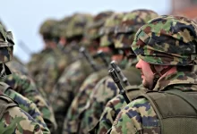 man in green and brown camouflage uniform holding black rifle