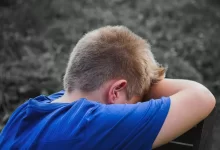 Close-up Photo of Sad Child leaning on a Wooden Chair