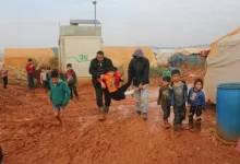 Ethnic kids and adults walking on dirty road