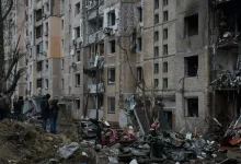 a group of people standing in front of a pile of rubble
