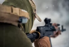 a man with a hat holding a rifle