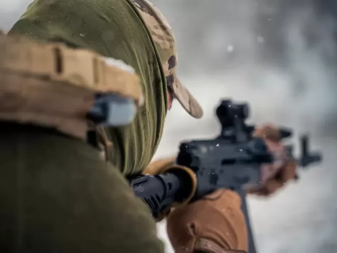 a man with a hat holding a rifle