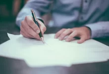 man writing on paper