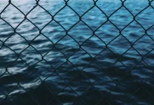 body of water in front of chain link fence