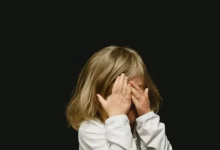 girl covering her face with both hands