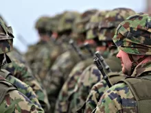 man in green and brown camouflage uniform holding black rifle