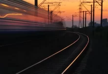 Rail Road Under Gray and Orange Cloudy Sky during Sunset