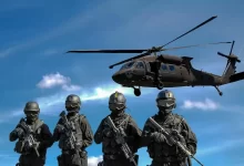 Four Soldiers Carrying Rifles Near Helicopter Under Blue Sky