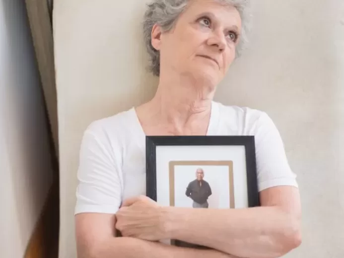 Elderly Woman Holding a Photo Frame