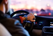 man driving a car wearing wrist watch