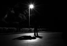 a person laying on the ground under a street light