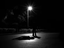 a person laying on the ground under a street light