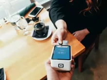 person holding credit card swipe machine
