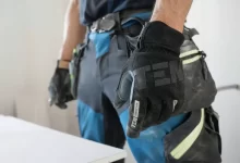 a man wearing a pair of black and blue work gloves