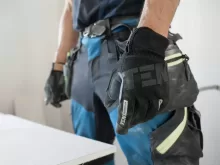 a man wearing a pair of black and blue work gloves