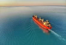 red and white cargo ship at middle of ocean