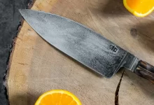 sliced orange fruit beside stainless steel knife