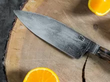 sliced orange fruit beside stainless steel knife
