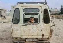 Boy sitting in broken car