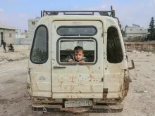 Boy sitting in broken car