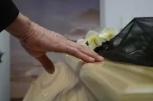 A Person Touching a Wooden Coffin