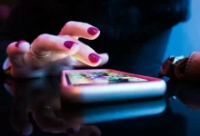 person using black smartphone with gray and pink case