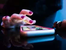 person using black smartphone with gray and pink case