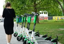 woman walking beside parked electric scooters