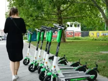 woman walking beside parked electric scooters
