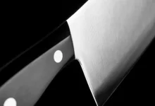grayscale photo of gray cleaver with black handle
