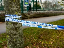 a close up of a blue and white police tape on a tree