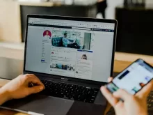 person using both laptop and smartphone