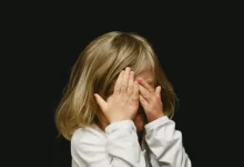 girl covering her face with both hands