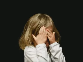 girl covering her face with both hands