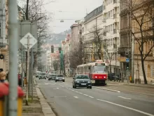 a red and white bus driving down a street next to tall buildings