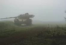 a tank driving through a foggy field