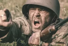 a man in a helmet is holding a rifle