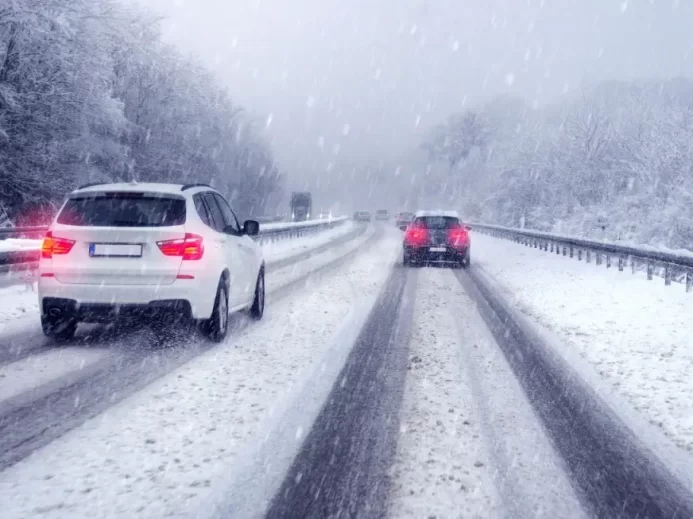 Auta jedoucí po dálnici ve vánici